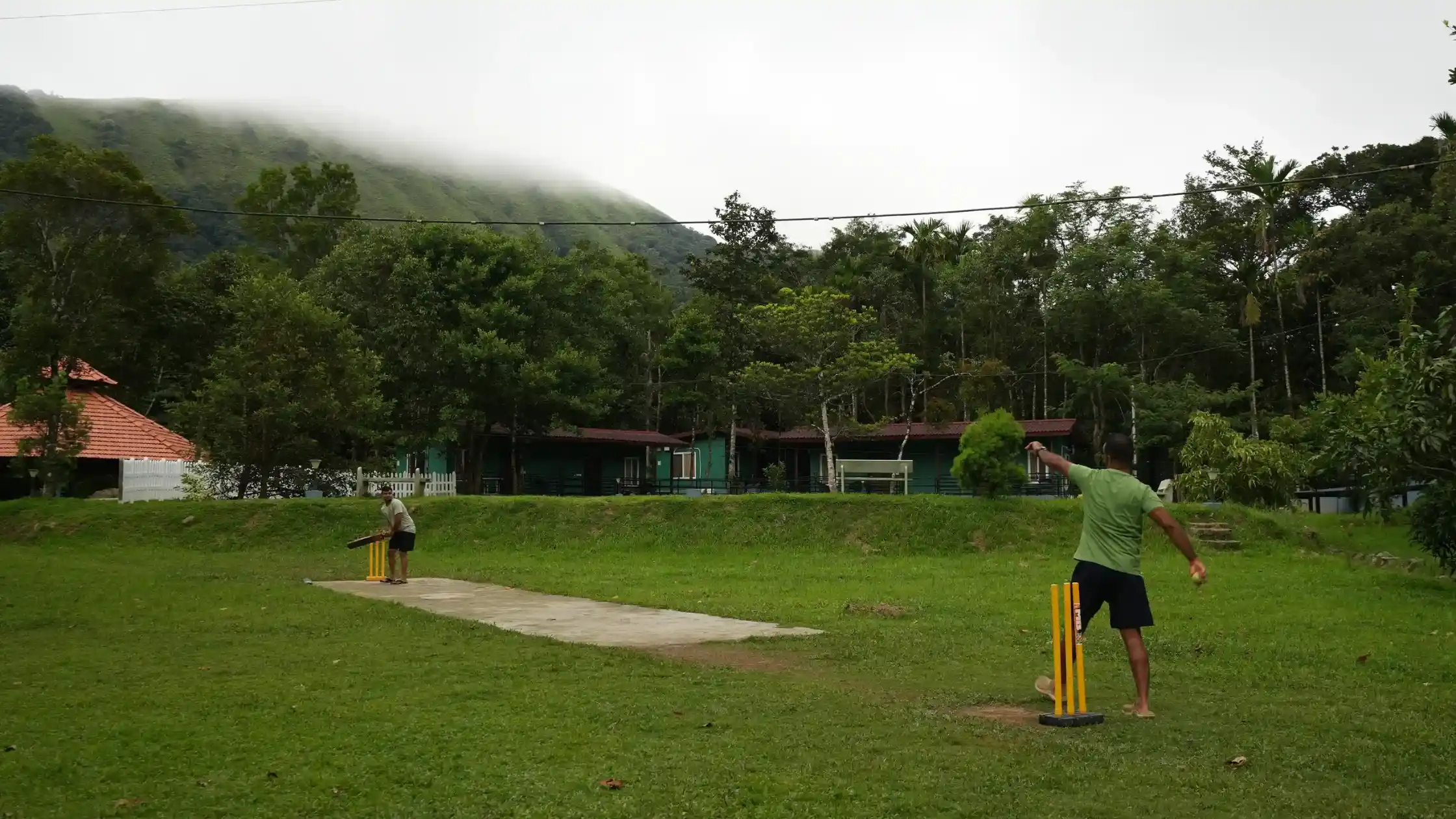Cricket game at a Sakleshpur resort with misty hills
